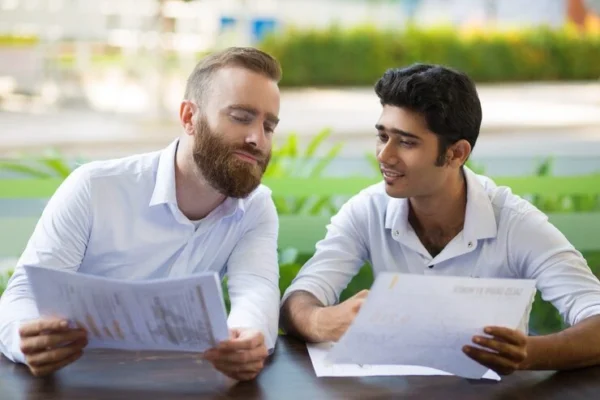 Two tax professionals collaborating on annual crypto tax filing and planning, reviewing digital asset reports and blockchain transaction data.