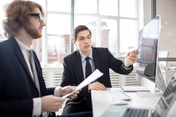 Two tax advisors reviewing documents and digital records together while providing support for an HMRC investigation.